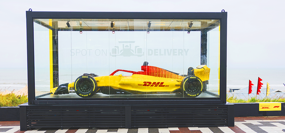 Afbeelding van een tentoongestelde raceauto van DHL, bij Circuit Zandvoort.